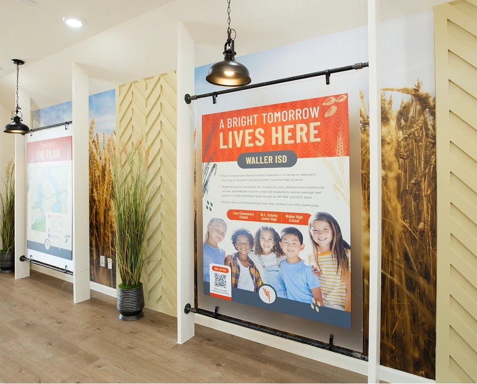 Large poster for Waller ISD in Waller TX features kids’ photos, displayed in a well-lit hallway.