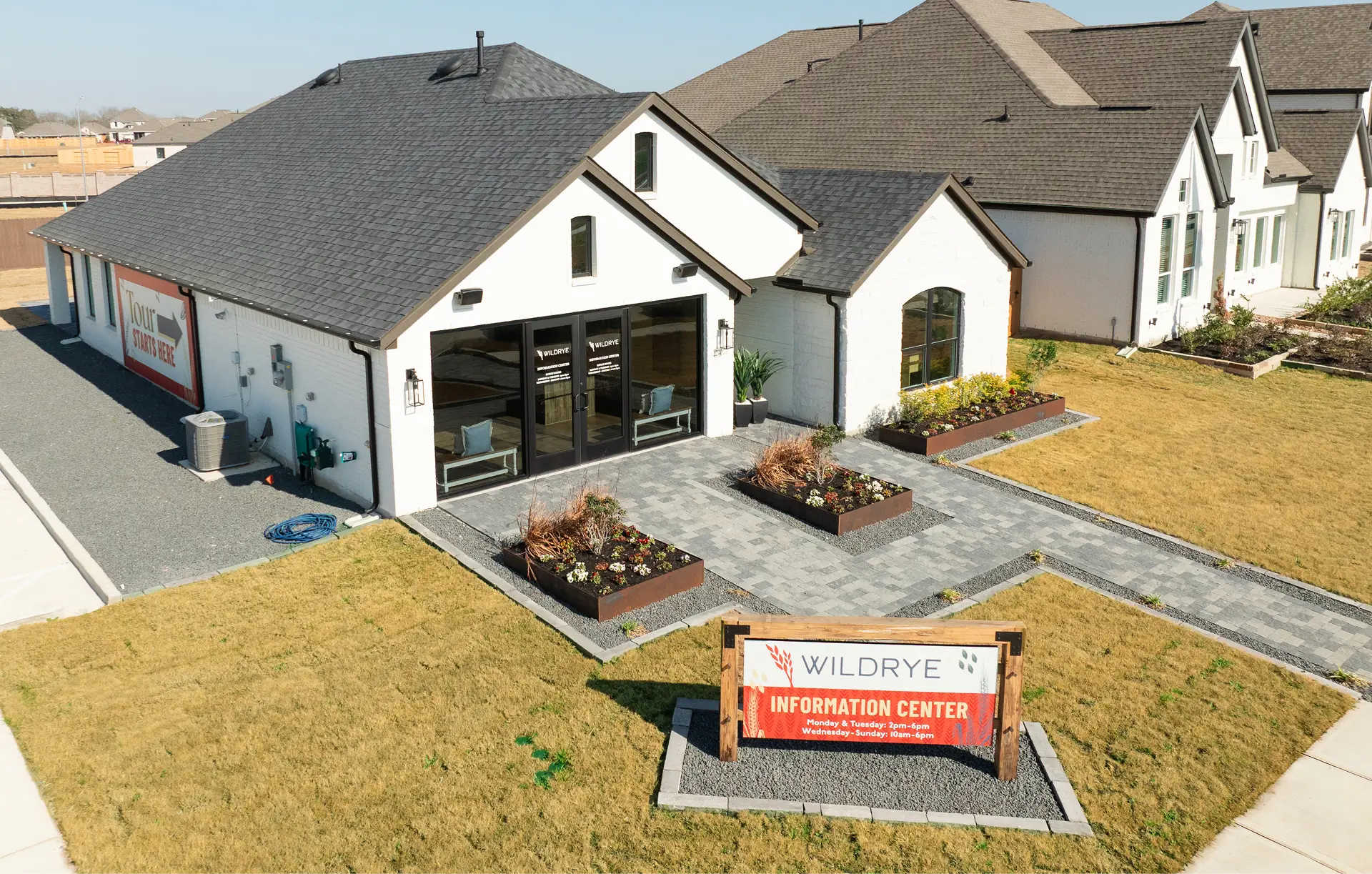 Single-story Wildrye Information Center in Waller TX, sign displayed in front yard.